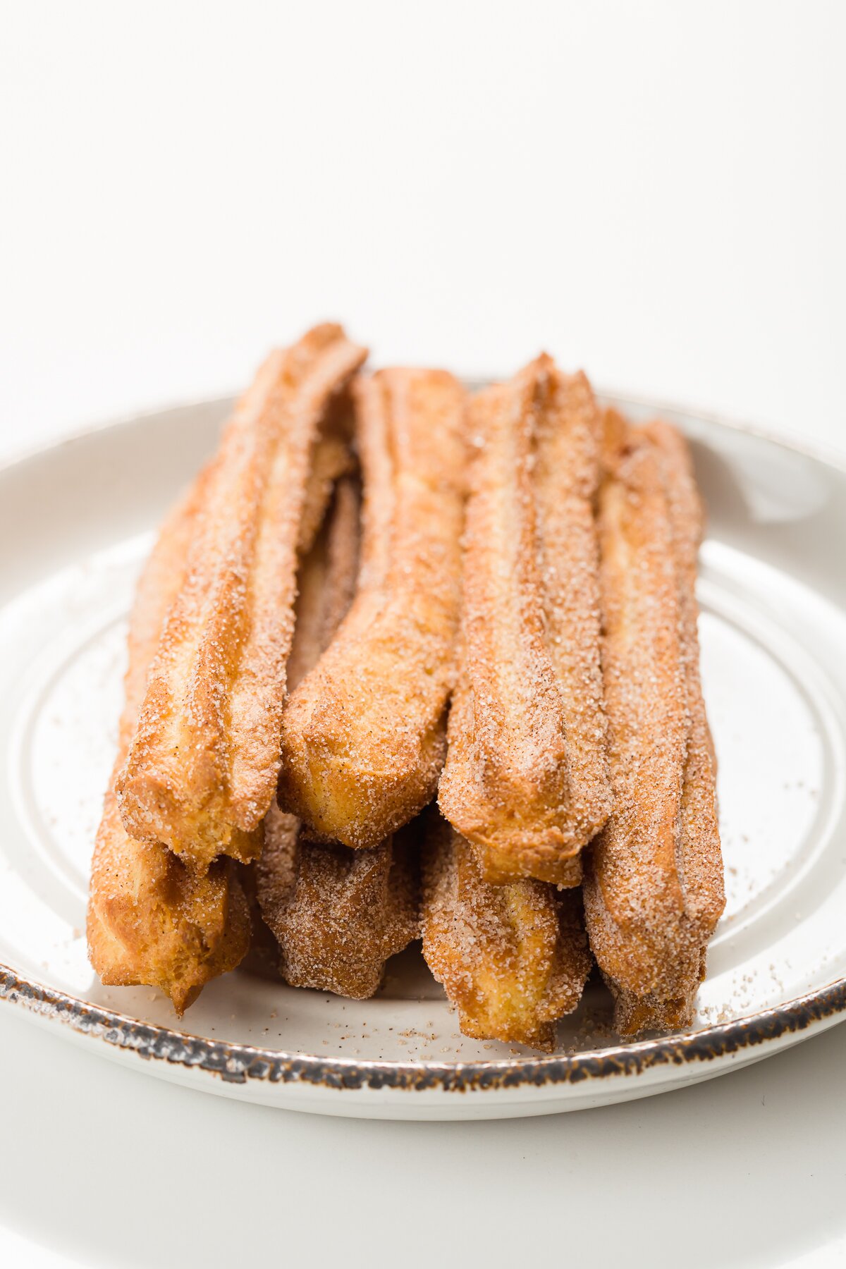 Stack of churros on a white plate