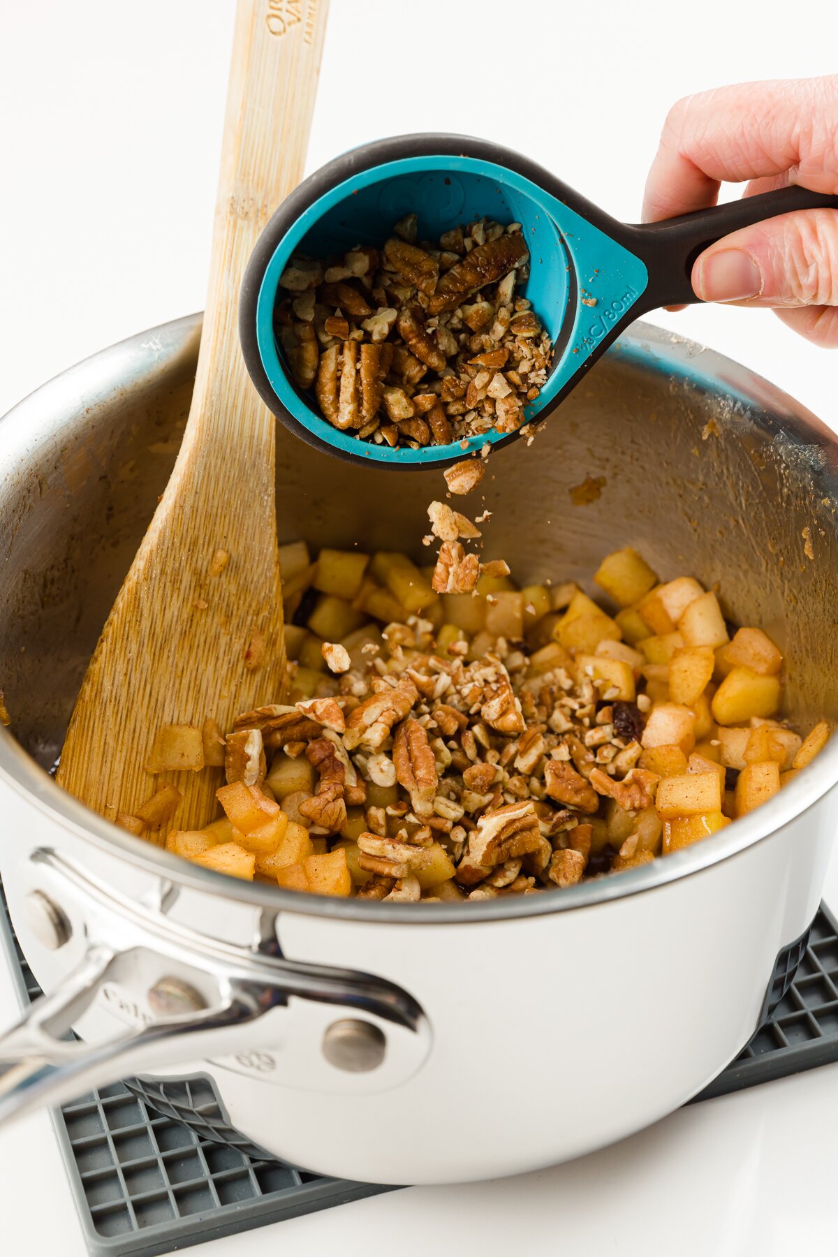 Adding nuts to pot of cooked apples