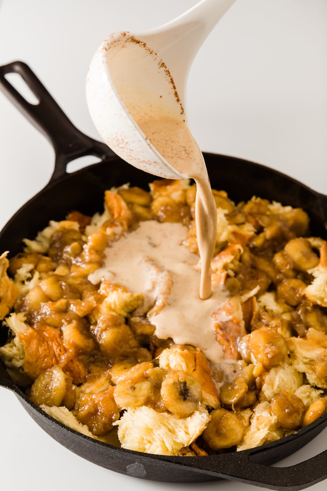 pouring liquid over baked French toast casserole