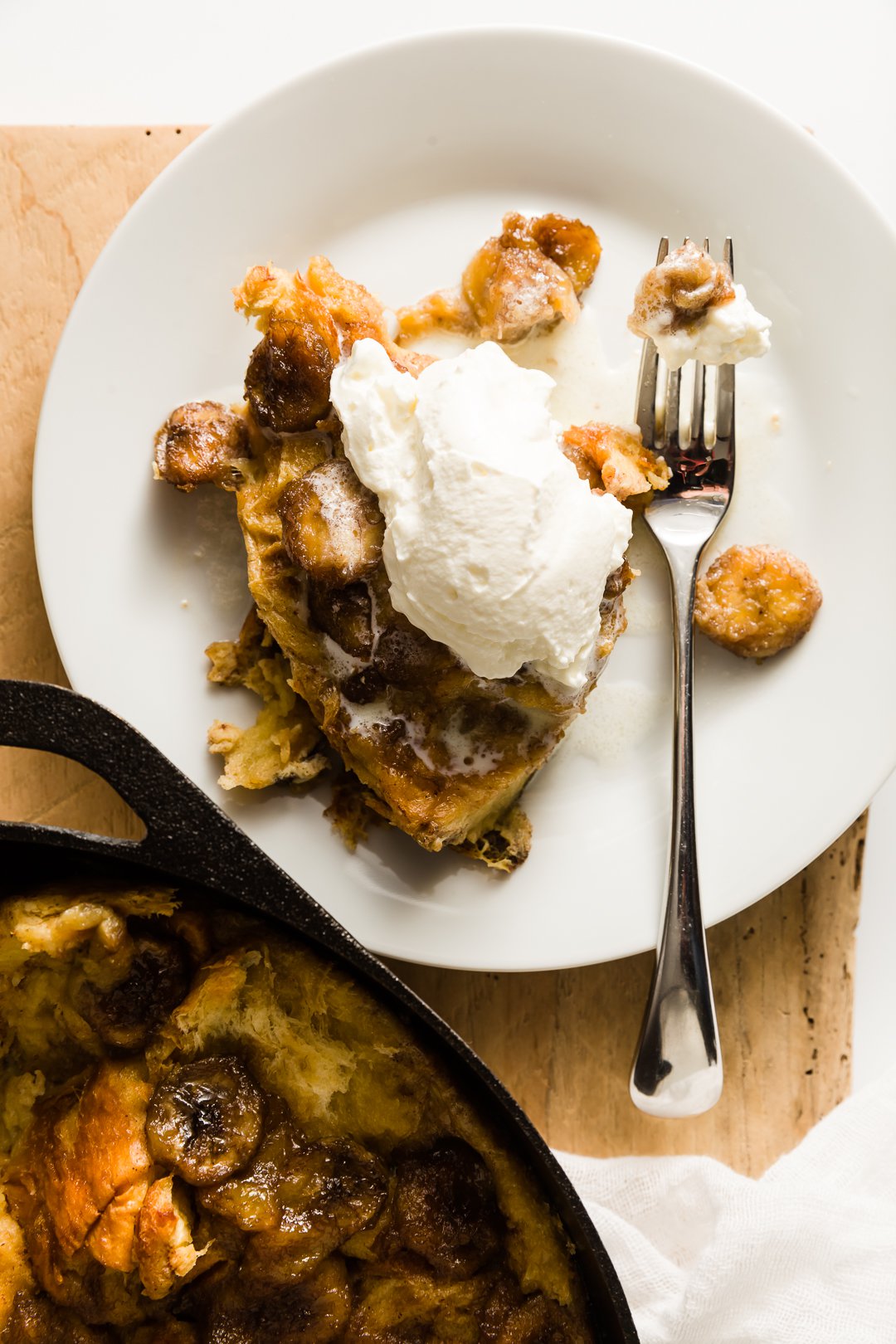 Bananas Foster french toast on a plate with a dollop of whipped cream