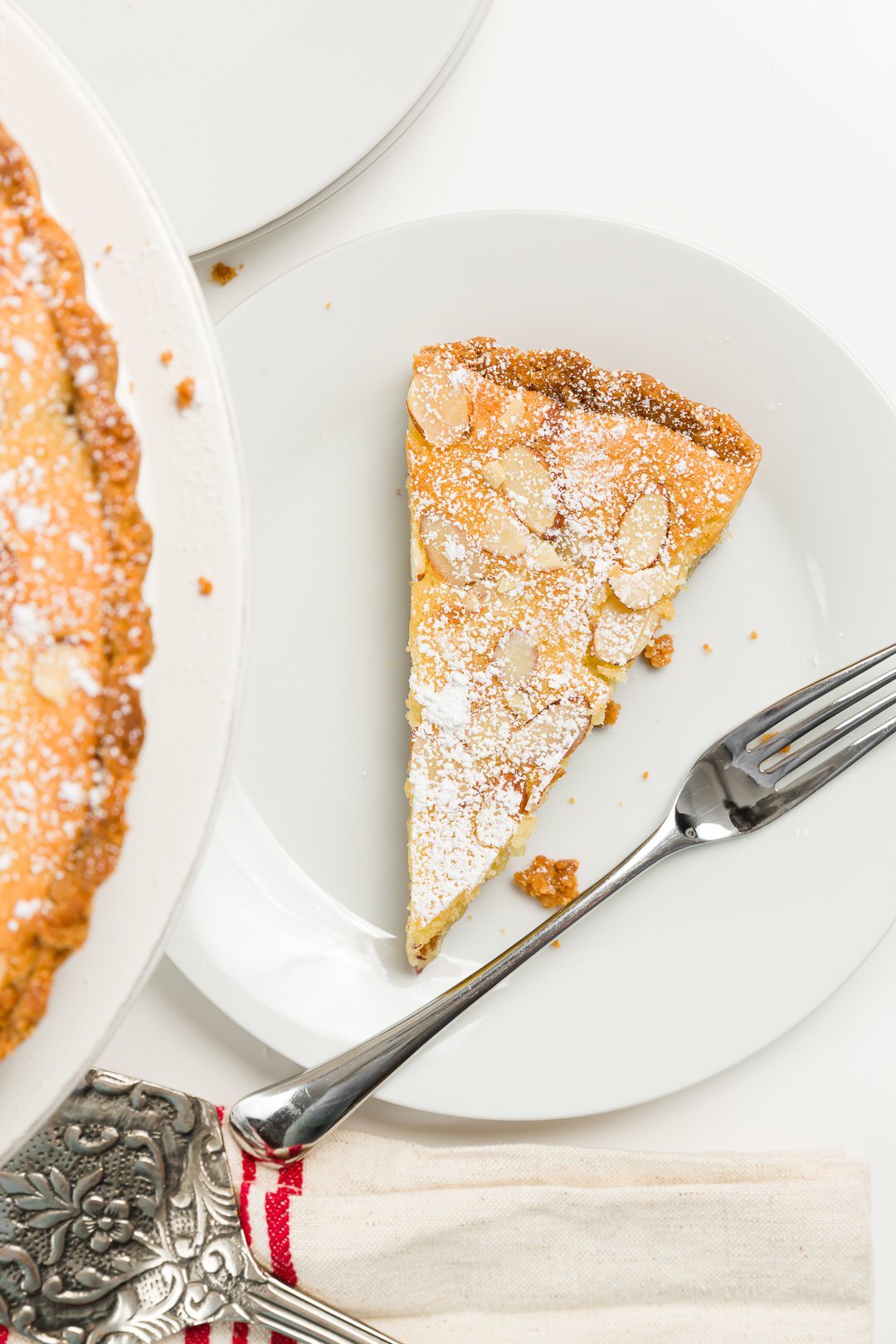 Top down shot of a slice of tart on a white plate with a fork on the plate