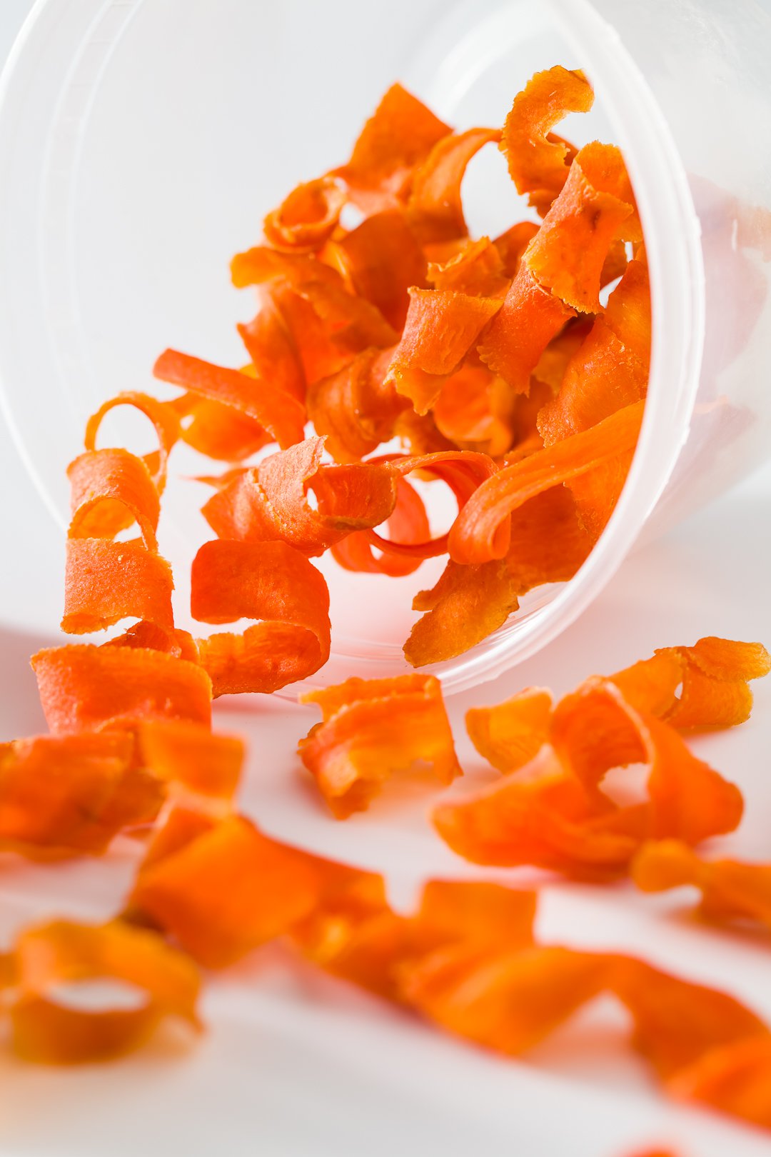 A spilled plastic container of candied carrot curls.