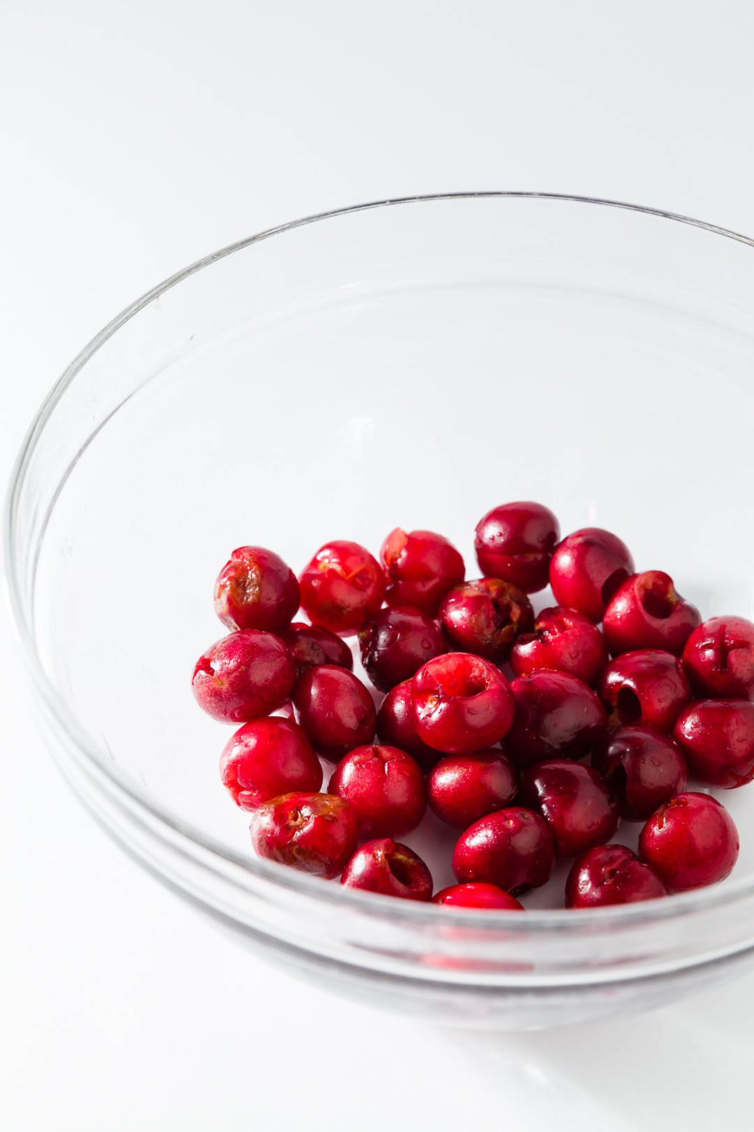A glass bowl of pitted cherries
