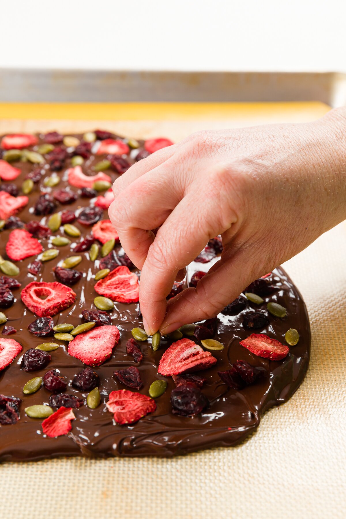 Placing a pumpkin seed on chocolate bark