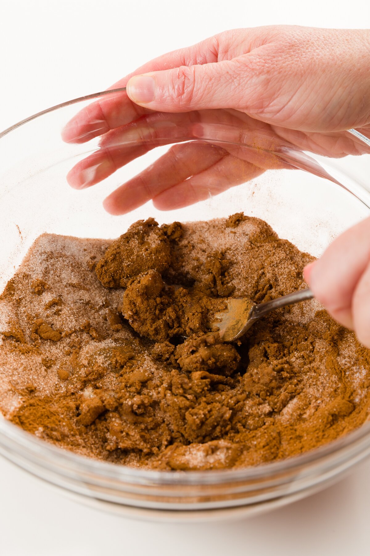 Mixing cinnamon and other ingredients in a glass bowl with a fork