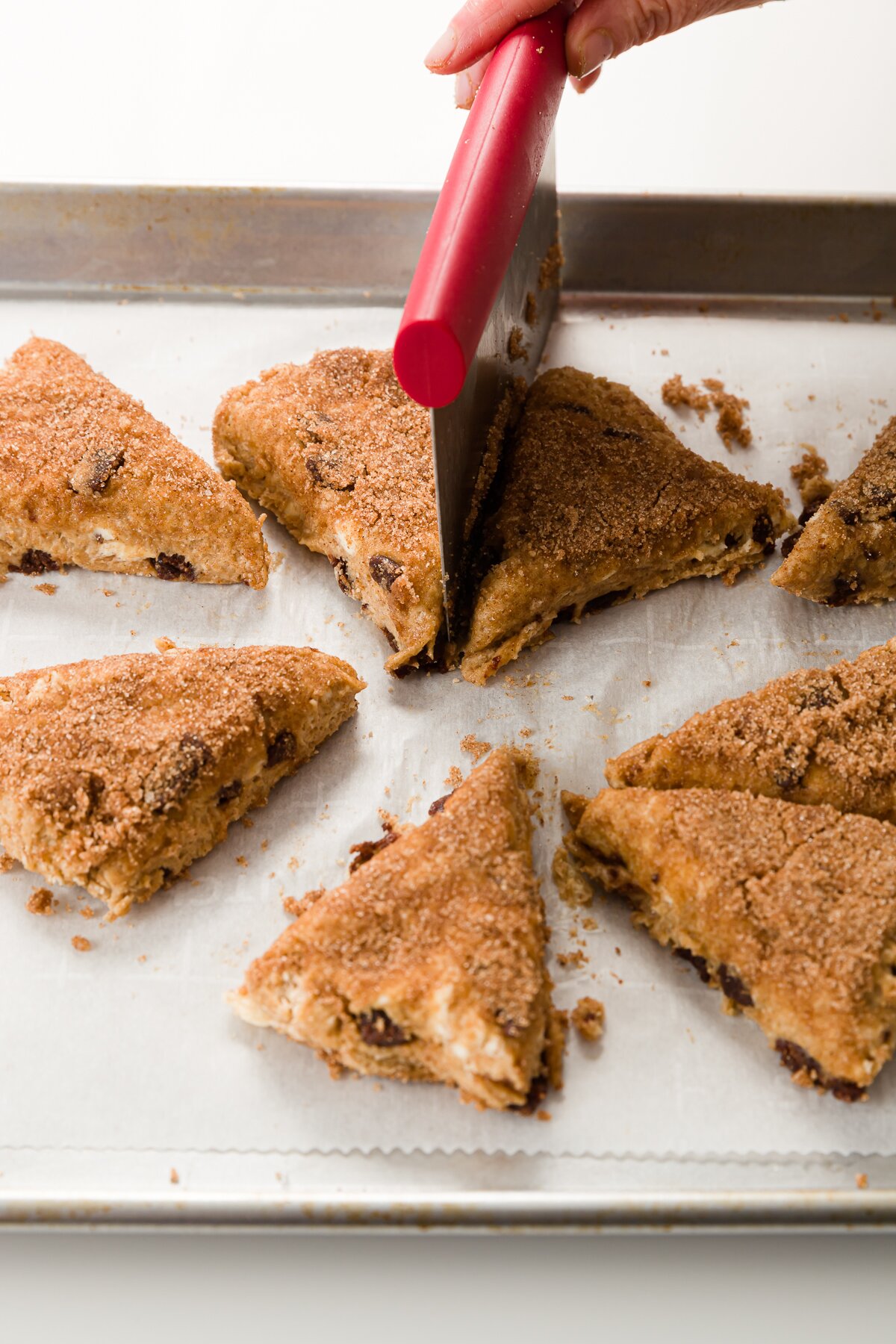 Using a bench scraper to cut scone dough into in sections.