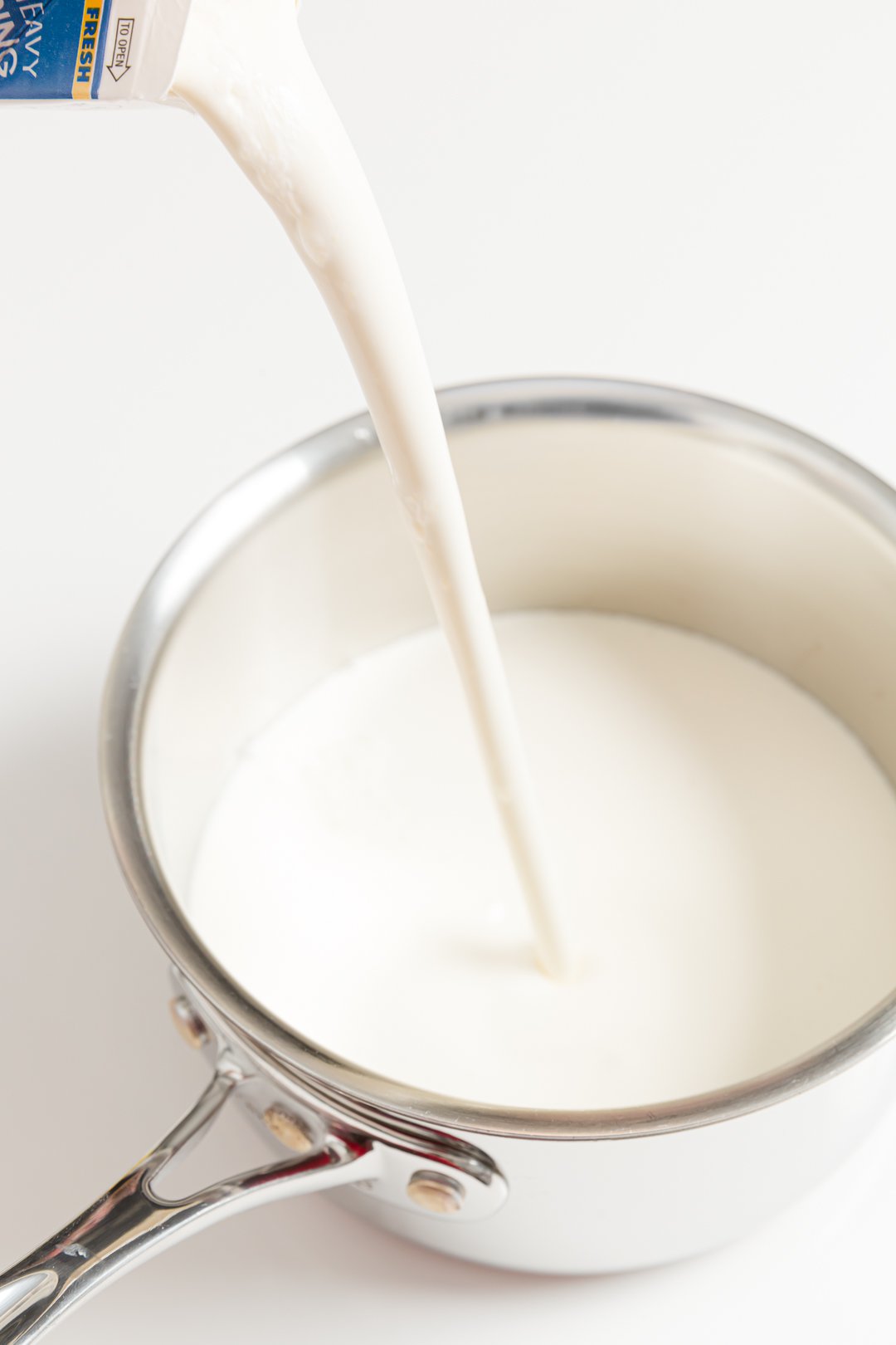 Pouring heavy whipping cream into a pot