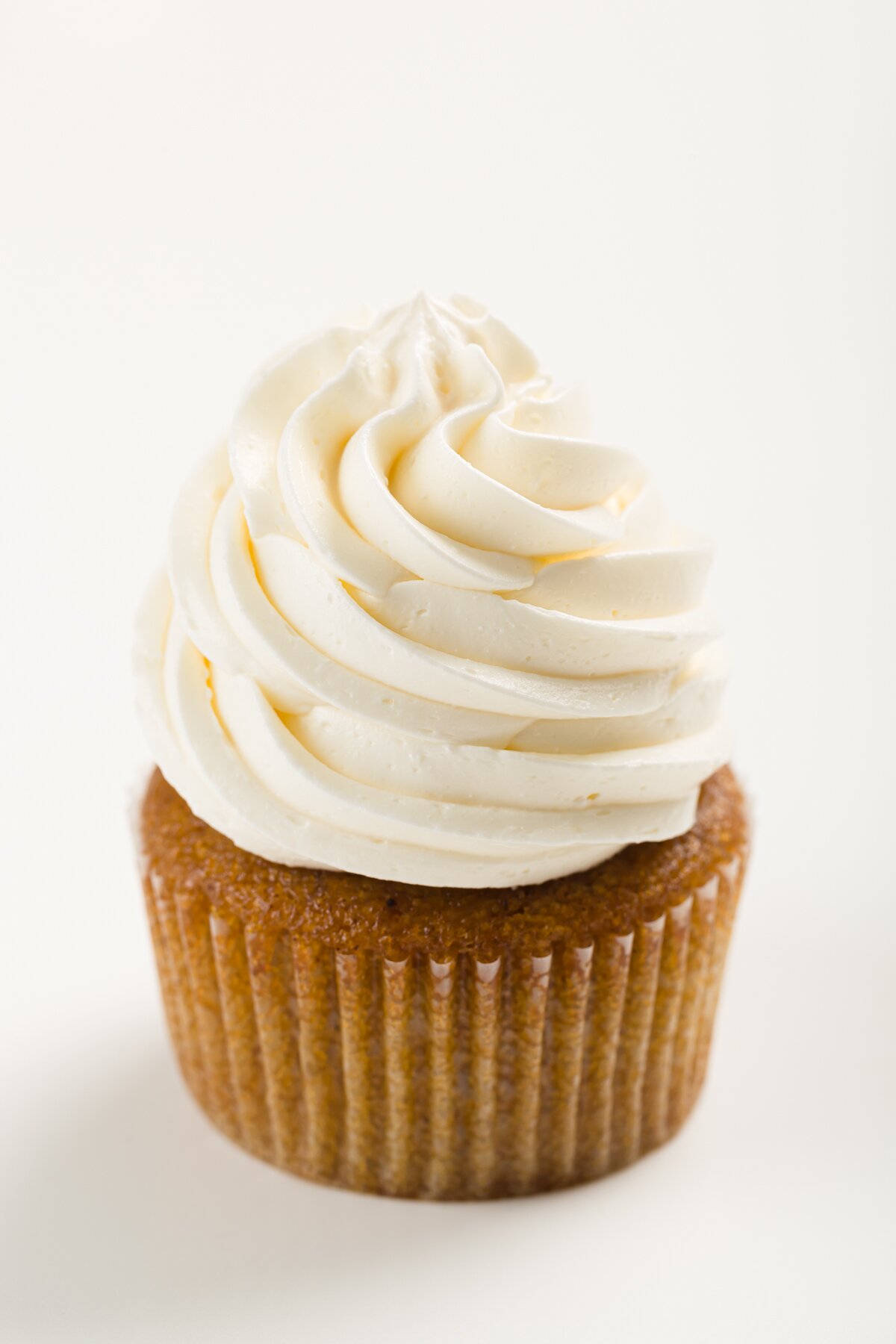 tight shot of a cupcake frosted with Italian meringue buttercream frosting