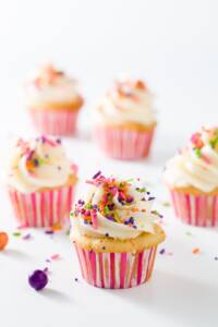 A group of mini cupcakes in pink and white liners
