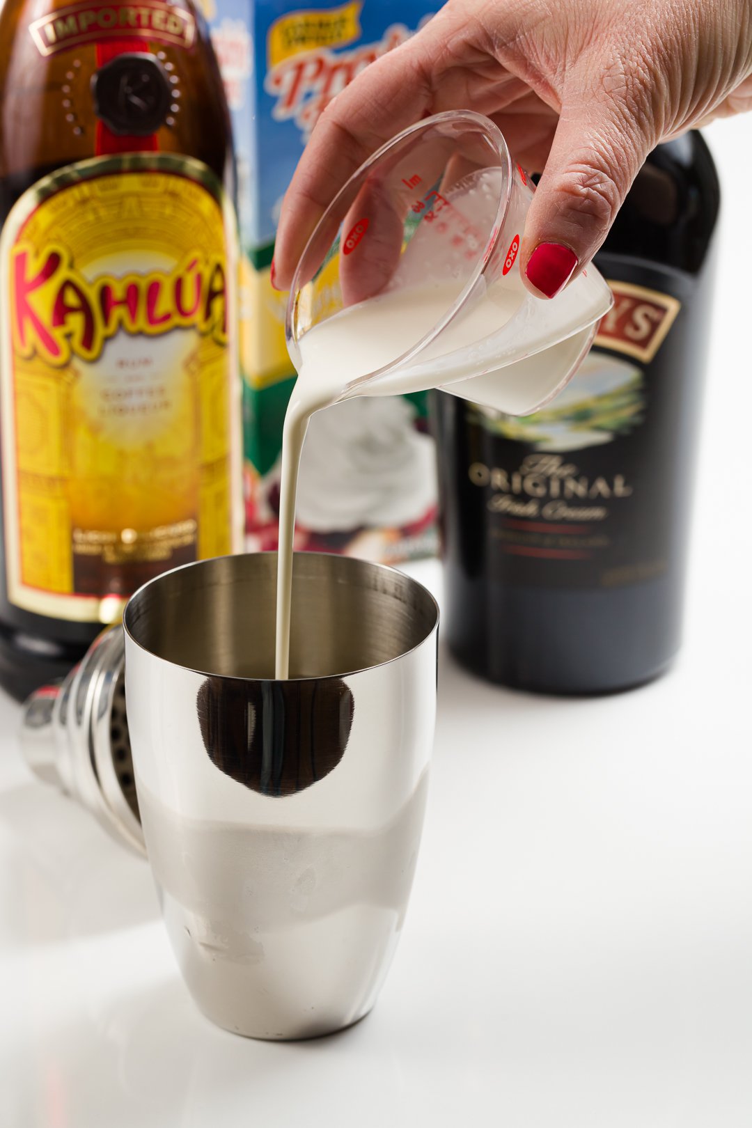 heavy cream added to a cocktail shaker with ice to make a mudslide cocktail