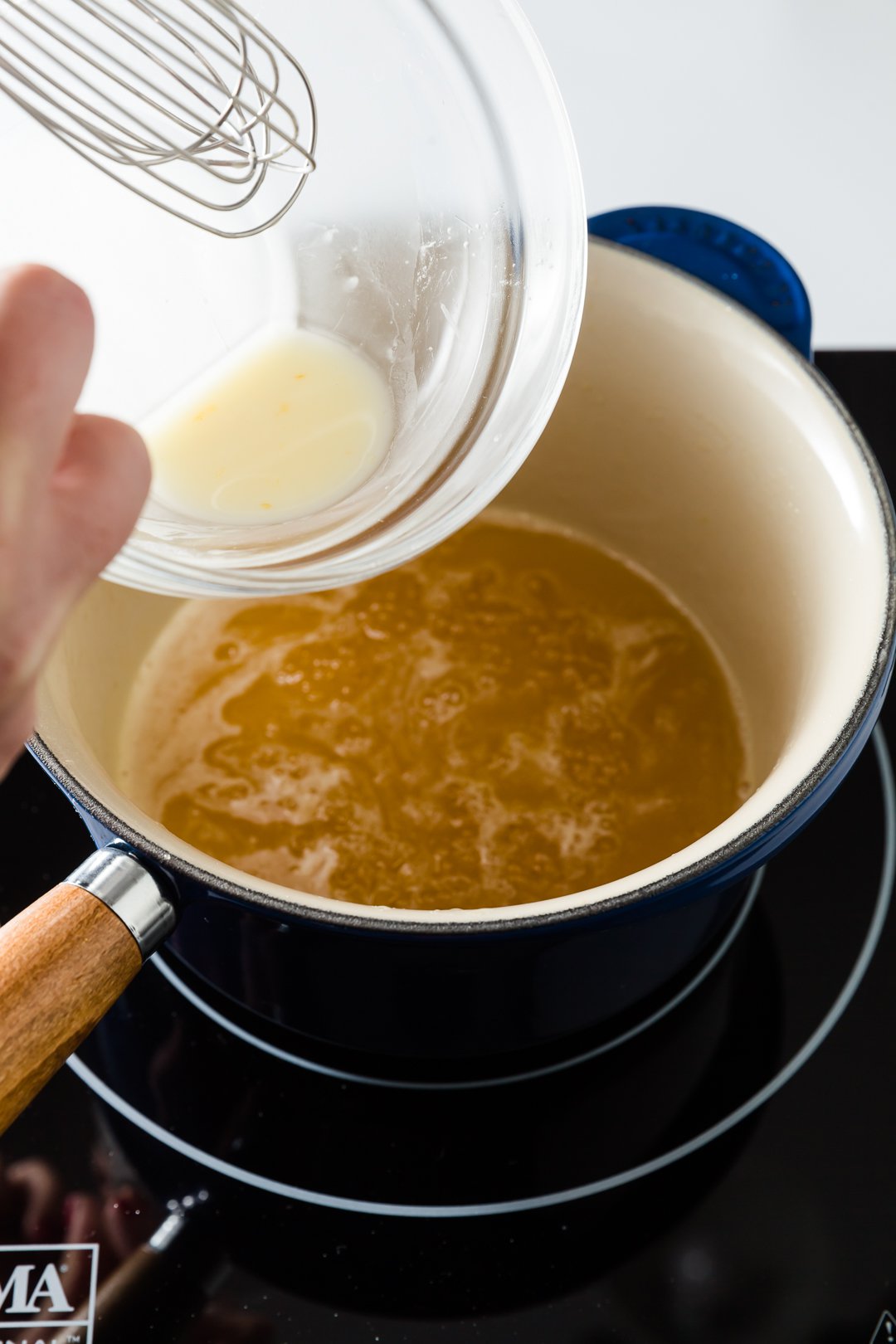 Adding cornstarch slurry to boiling orange sauce