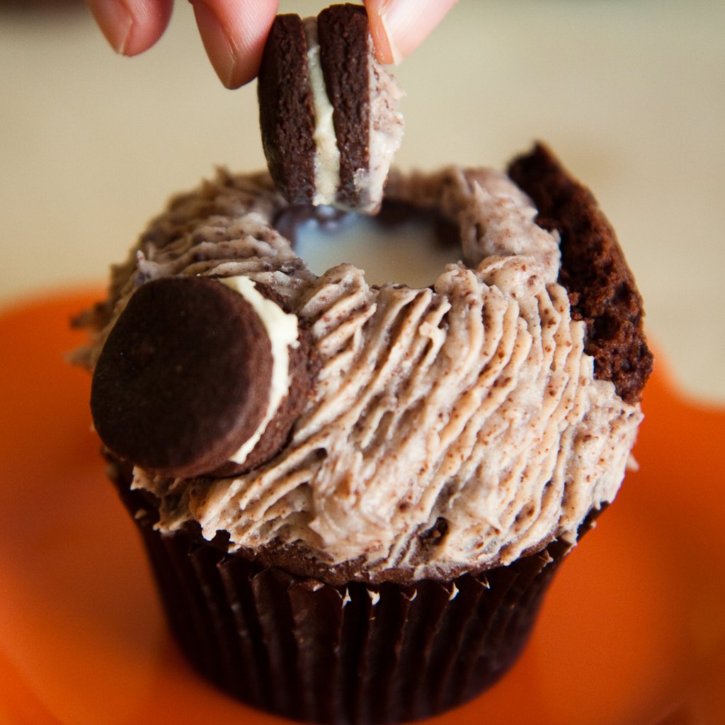 Dunking a mini oreo into an Oreo cupcake
