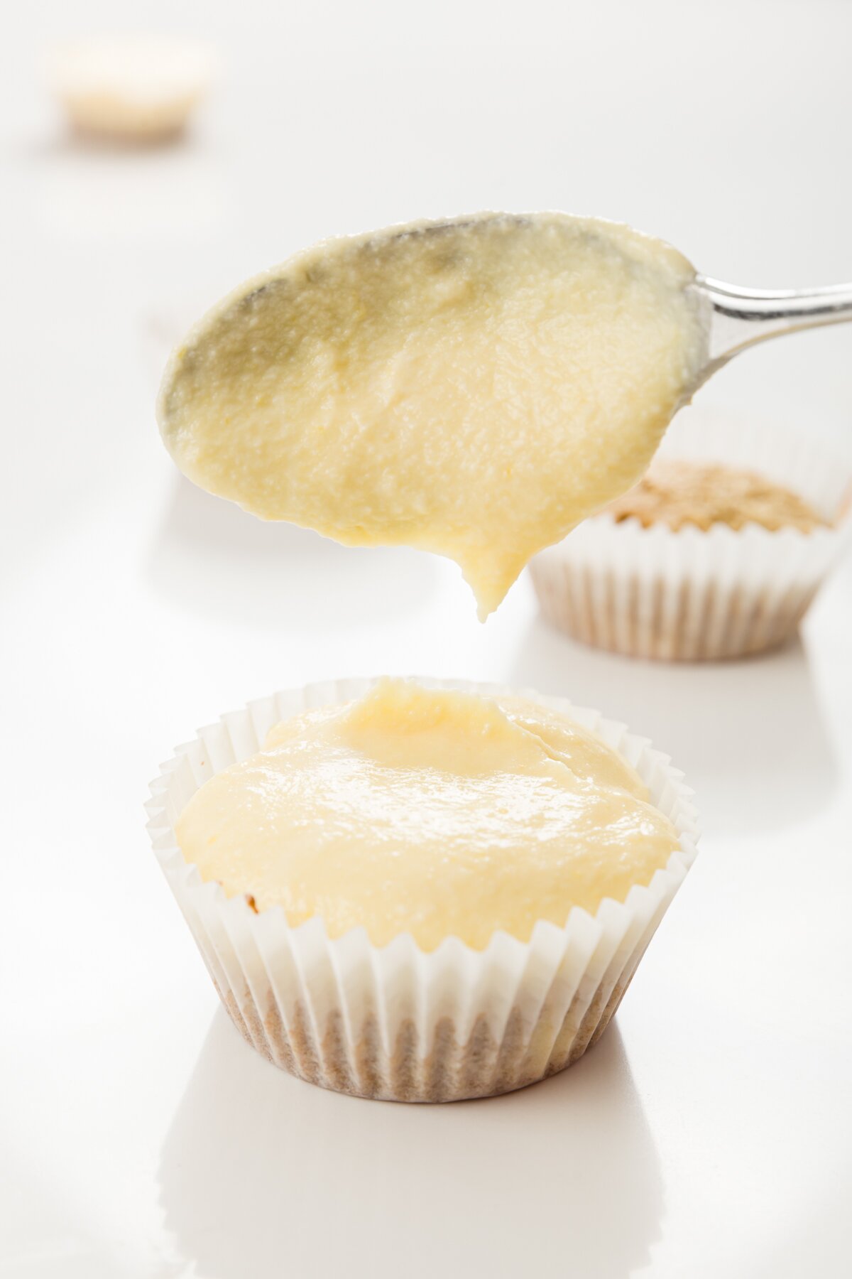 tight shot of Stef putting the custard mixture on top of a tiramisu cupcake