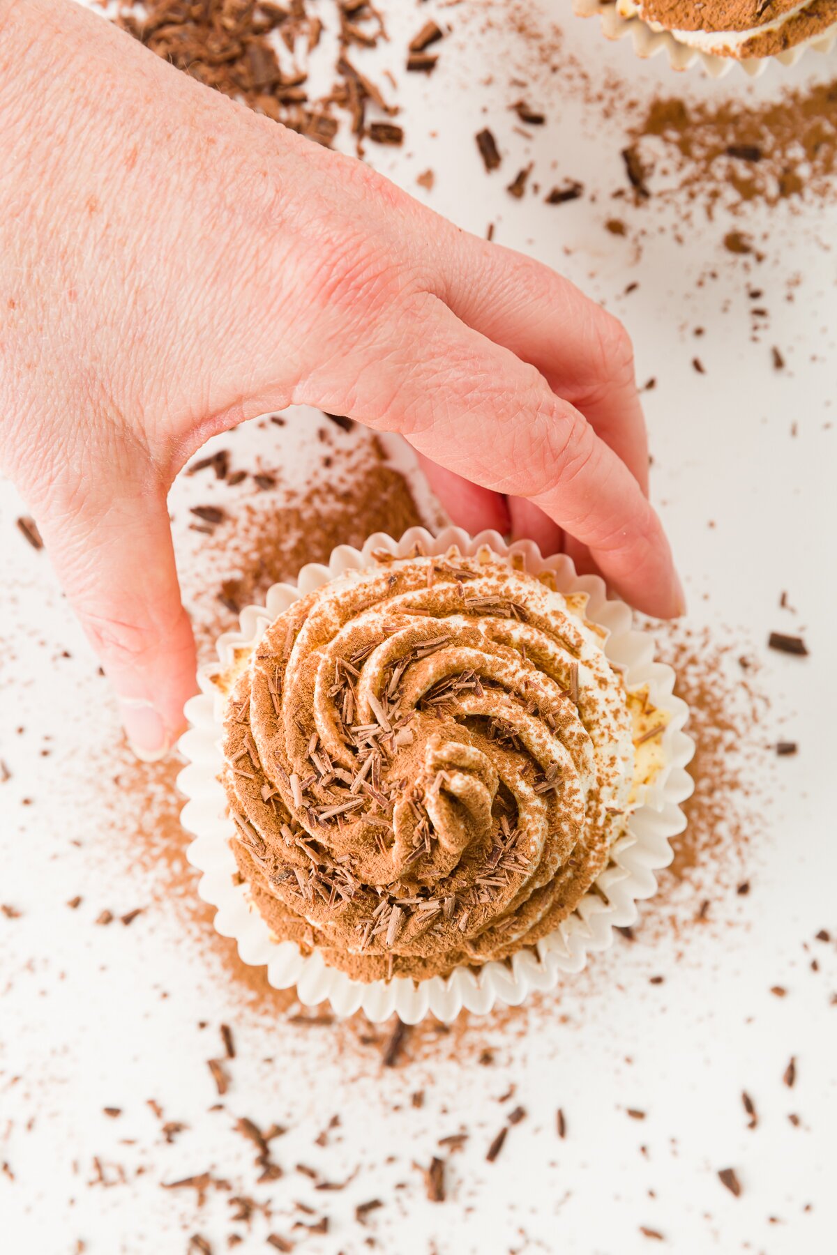 overhead shot of Stef's hand reaching for a tiramisu cupcake